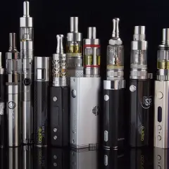 Une collection de cigarettes électroniques, dont une "SMOK", montrant la diversité des modèles et leurs définitions.