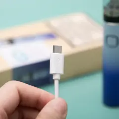 Main tenue, câble USB blanc pour recharger un appareil Innokin low volt.