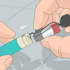 Mains pour recharger les accus d'un appareil électronique. Les fils sont connectés à une batterie et à un composant circulaire.