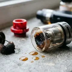 Résistance cigarette électronique cramé, coton noirci et liquide renversé. Un signe qu'il est temps de changer la résistance.