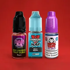 Trois flacons de e-liquide Vampire Vape, dont un Heisenberg, sur fond rouge.