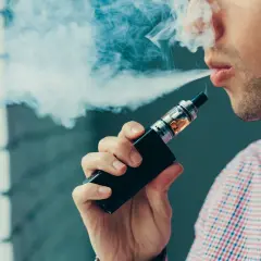 Un homme exhale une vapeur bleutée. Sa cigarette électronique fait un bruit de bulle, un son apaisant dans le silence.
