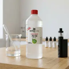Bouteille d'e liquide perimé, bécher avec pipette, cigarette électronique et flacons sur une table en bois.