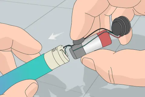 Mains pour recharger les accus d'un appareil électronique. Les fils sont connectés à une batterie et à un composant circulaire.