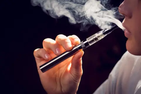 Une personne utilise une cigarette électronique, un pas vers le sevrage du vapotage et de la nicotine.
