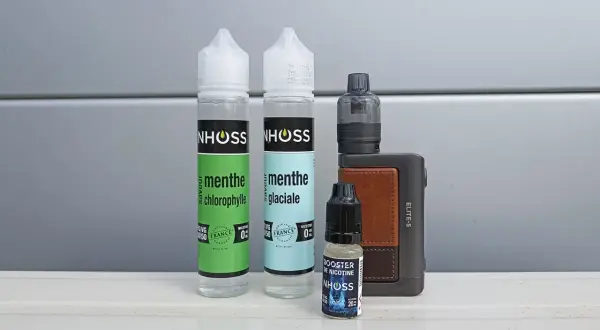 Flacons de e-liquide menthe et booster de nicotine, avec une cigarette électronique. Le propylène glycol, composant principal, peut présenter un danger s'il est mal utilisé.