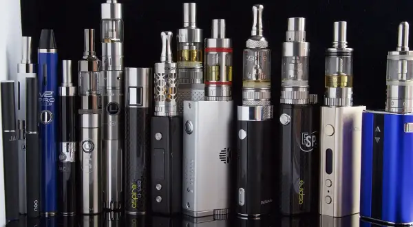 Une collection de cigarettes électroniques, dont une "SMOK", montrant la diversité des modèles et leurs définitions.