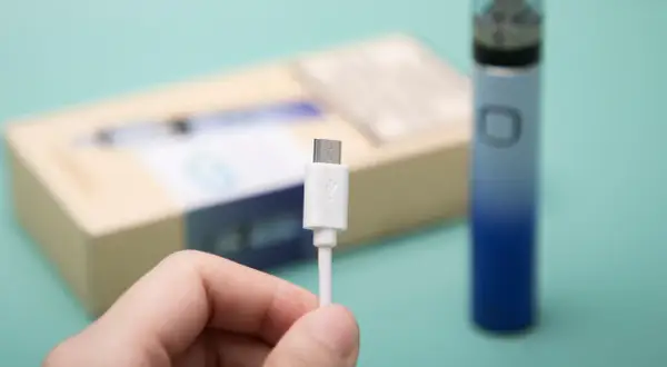 Main tenue, câble USB blanc pour recharger un appareil Innokin low volt.