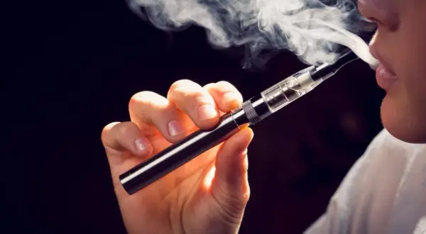 Une personne utilise une cigarette électronique, un pas vers le sevrage du vapotage et de la nicotine.