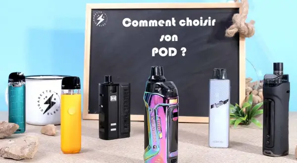 Plusieurs modèles de smok pod colorés et noirs sont alignés devant un tableau noir.
