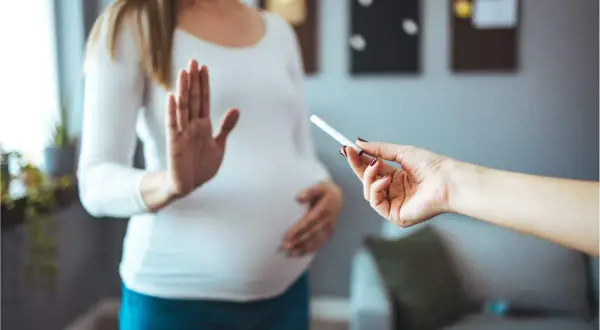 Femme enceinte refuse une cigarette électronique. Elle dit "non" à la tentation, car elle n'arrive pas à arrêter de vapoter.