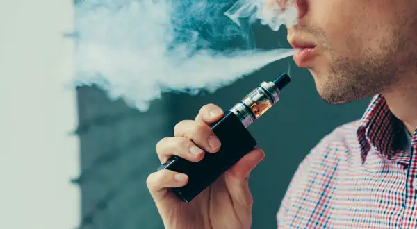 Un homme exhale une vapeur bleutée. Sa cigarette électronique fait un bruit de bulle, un son apaisant dans le silence.