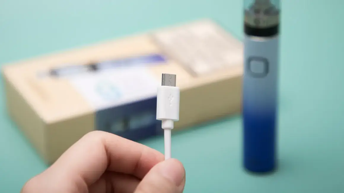 Main tenue, câble USB blanc pour recharger un appareil Innokin low volt.