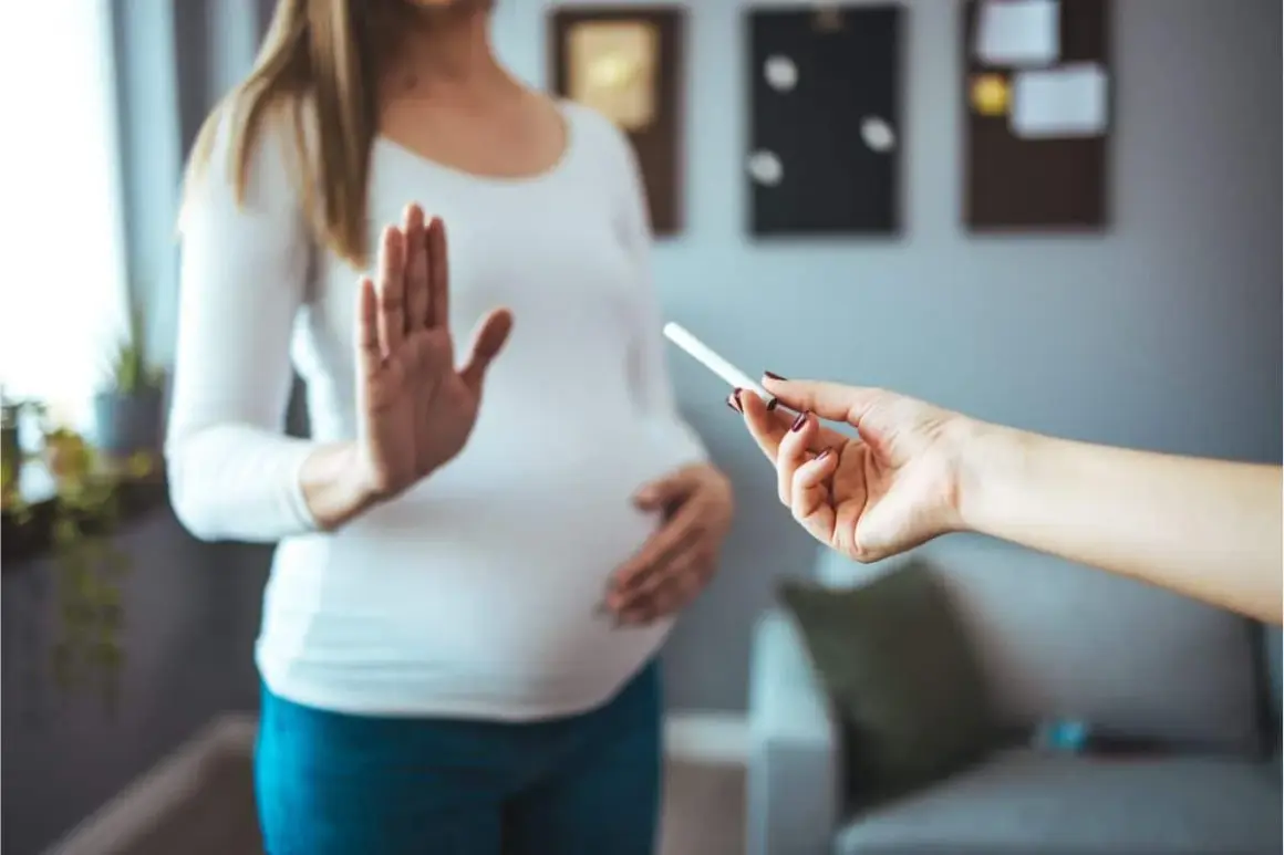 Femme enceinte refuse une cigarette électronique. Elle dit "non" à la tentation, car elle n'arrive pas à arrêter de vapoter.