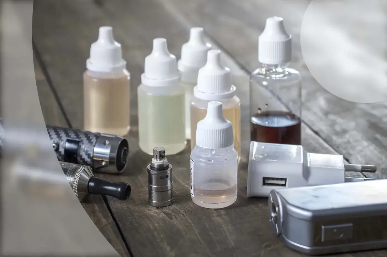 Flacons de e-liquide, certains contenant du propylène glycol, et des accessoires de cigarette électronique. Le propylène glycol peut présenter un danger.