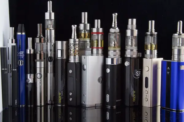 Une collection de cigarettes électroniques, dont une "SMOK", montrant la diversité des modèles et leurs définitions.