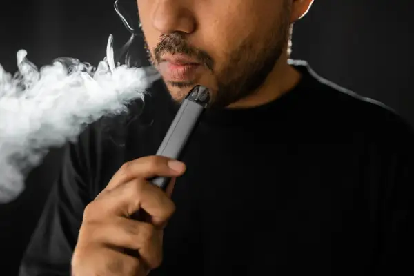 Un homme fume une cigarette électronique, une habitude qui peut avoir des conséquences sur le diabète.